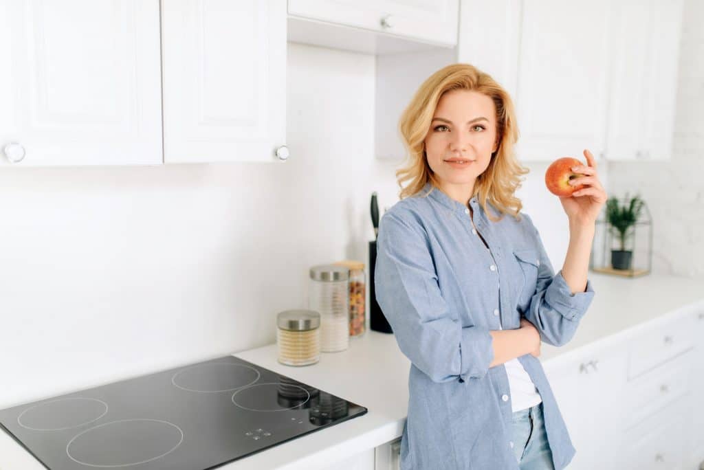 Woman poses on kitchen with snow-white interior