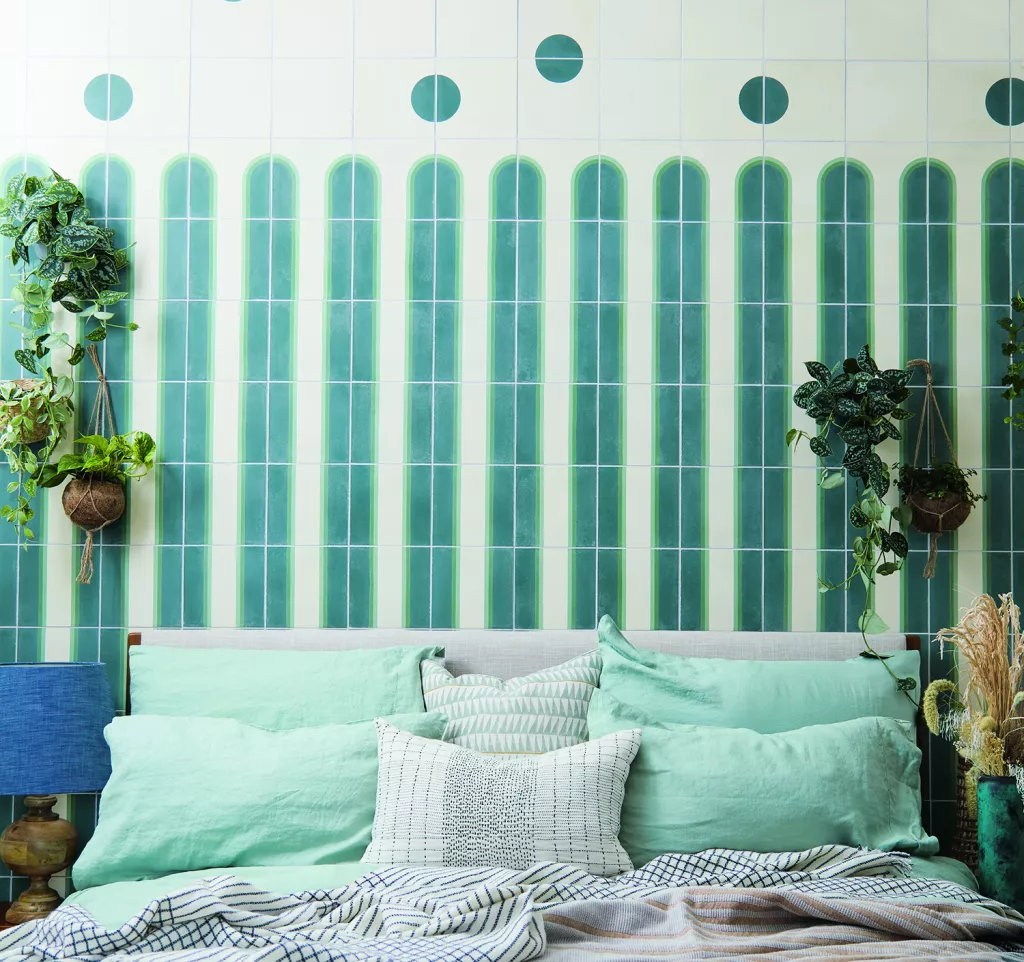 Tile with painted arches behind a bed, as part of the arch interior decoration style found on HomeDecorCraze.