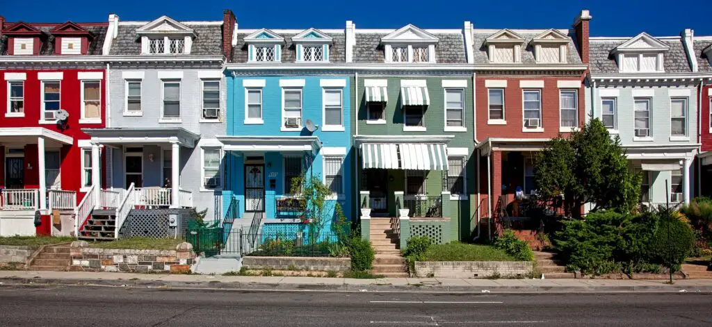 Row houses similar in architecture, but exhibiting in a variety of colors and front porch decor.